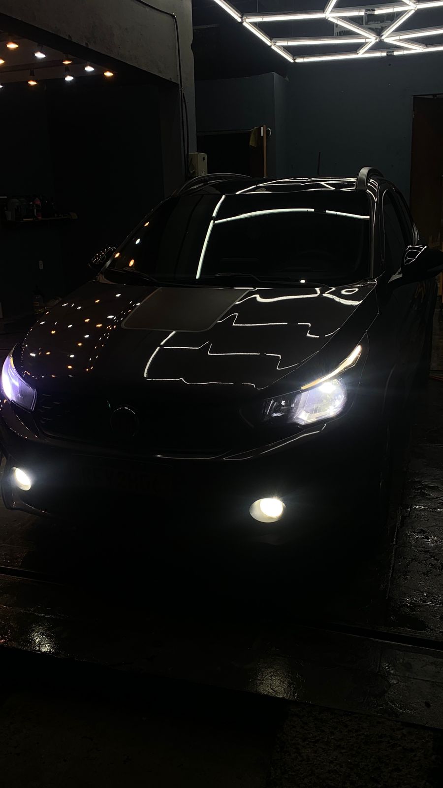 Carro premium à noite com faróis acesos após estética automotiva